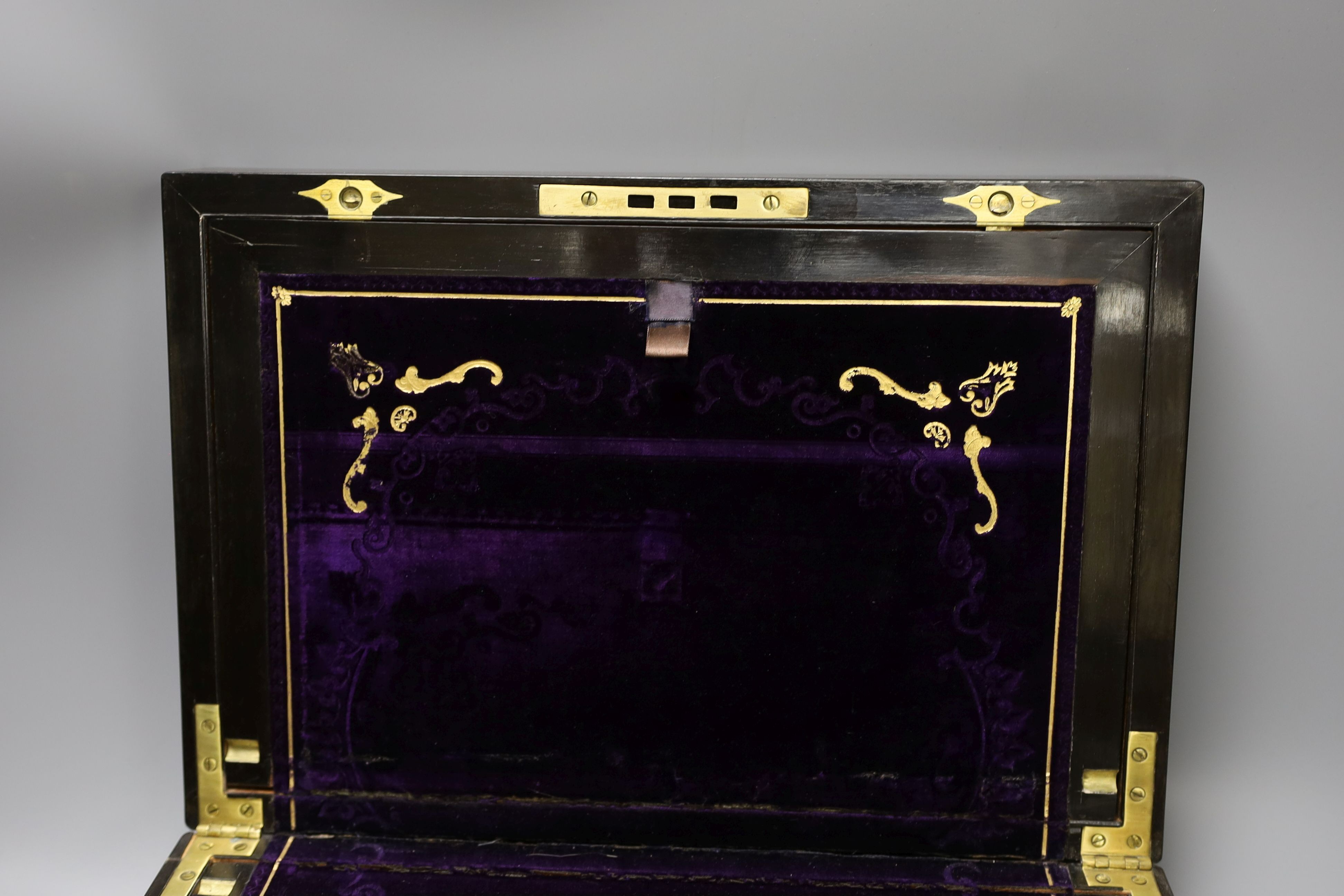 A 19th century coromandel wood writing slope with mother-of-pearl cartouche and original purple tooled velvet interior, 38 cms wide by 25 cms deep.